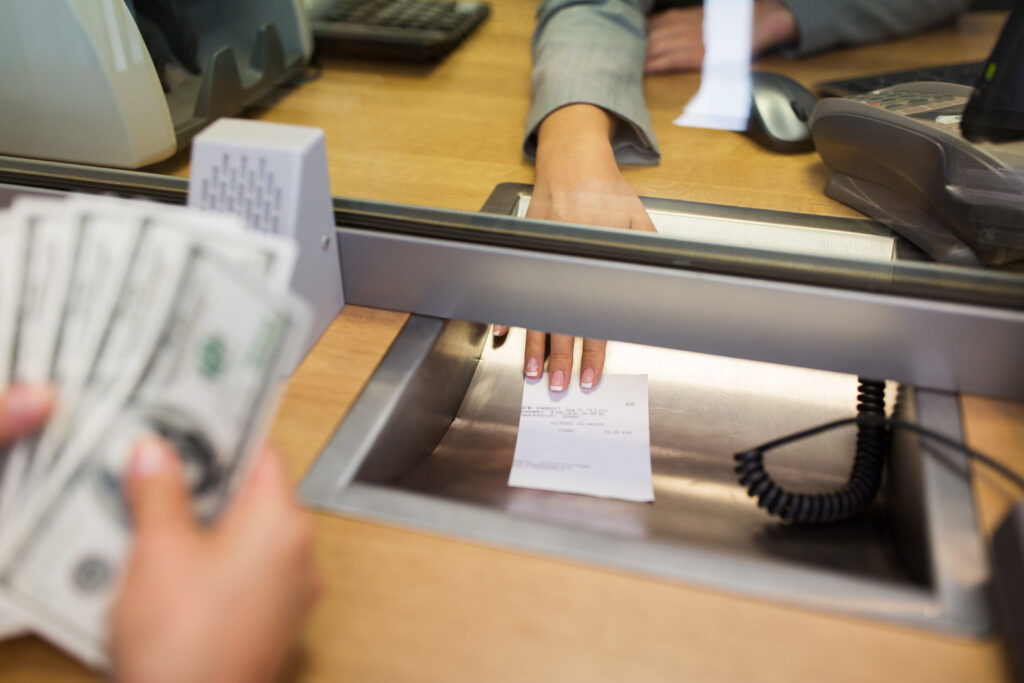 bank clerk giving receipt to customer after cashing a check