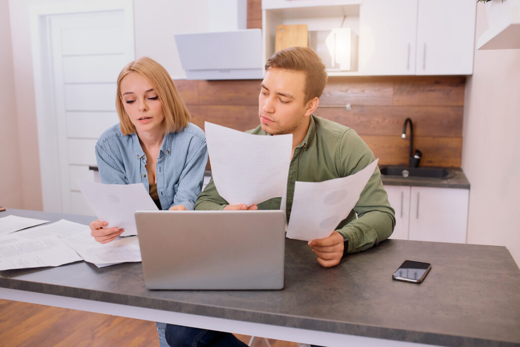 young couple reviewing paperwork to get ready to apply for a home loan